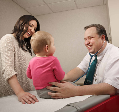 Mother and physician examining baby during exam